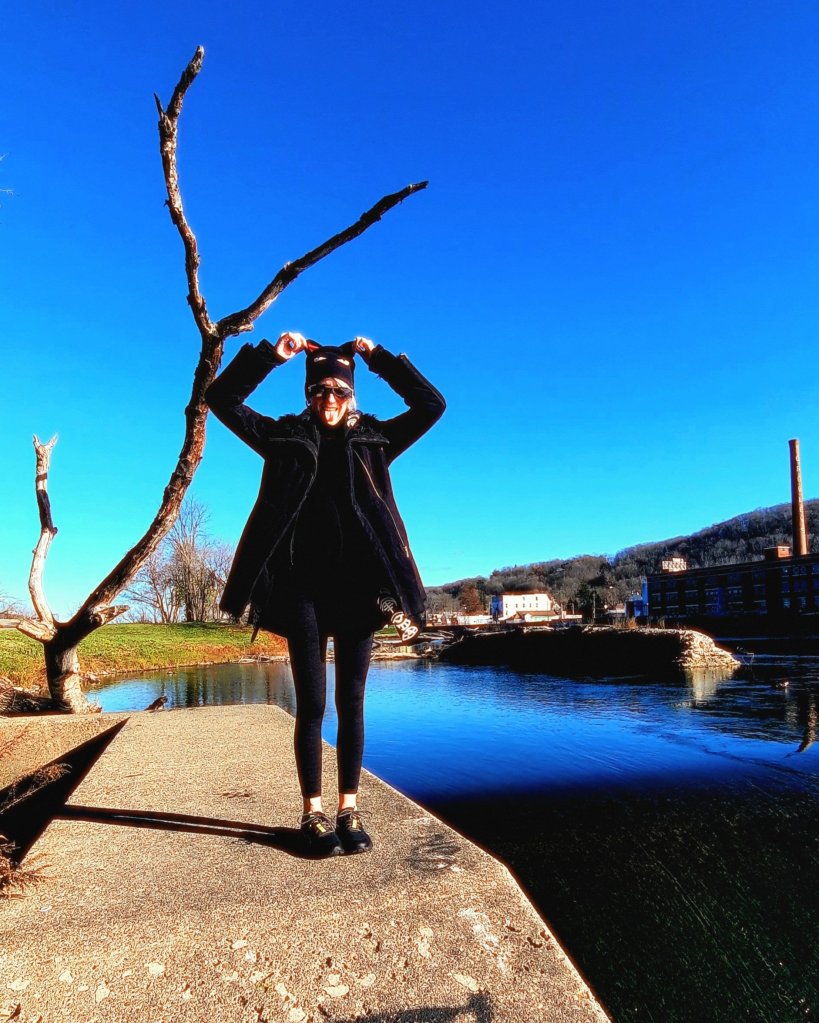 Kae Audhild playing near river confluence in Binghamton NY, upstate New York in mid November, Thanksgiving week 2023, alt goth girl aesthetic fashion style, Emily the strange sabbath black cat ear beanie, Prozis ambassador, fitness model, weekend strolls, walk more