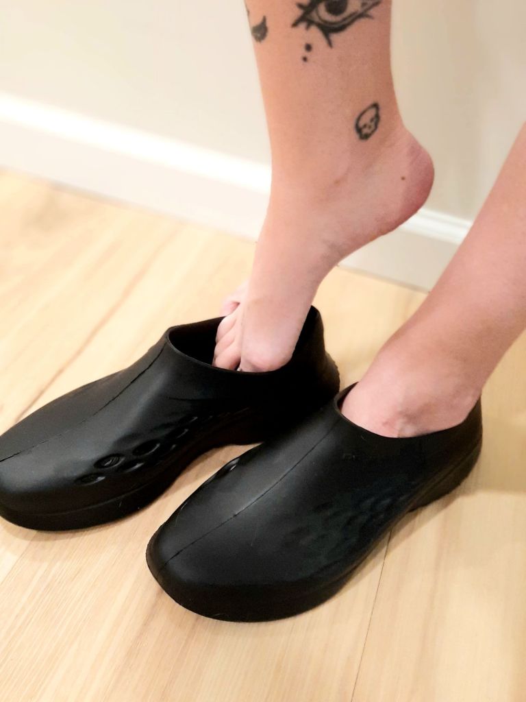 Kae Audhild's beautiful tattooed perfect big long toes narrow high arches feet sliding into black Prozis Apex RVF sneakers sports fitness activewear footwear luxury alt lifestyle blogger fitness and foot model, best recovery shoes for athletes, fitness sponsors, how do bloggers influencers celebrities models get gifted free stuff from luxury brands, goth women adults