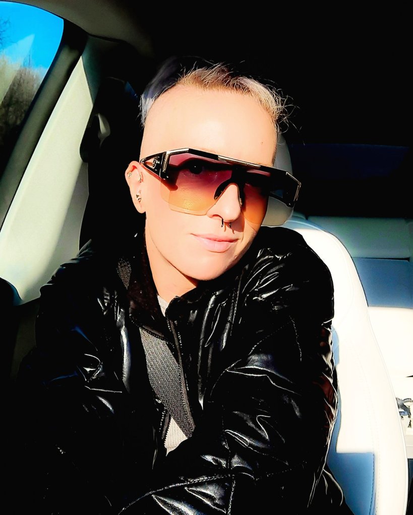 Kae Audhild Friday selfie, riding to Syracuse NY to play at central rock climbing gym in a tesla model y, alt goth punk scandi American lifestyle fitness travel beauty fashion blogger Amazon influencer affiliate, shein sxy shiny black puffer bomber jacket, shein large flat top ombre sunglasses, cny central new York