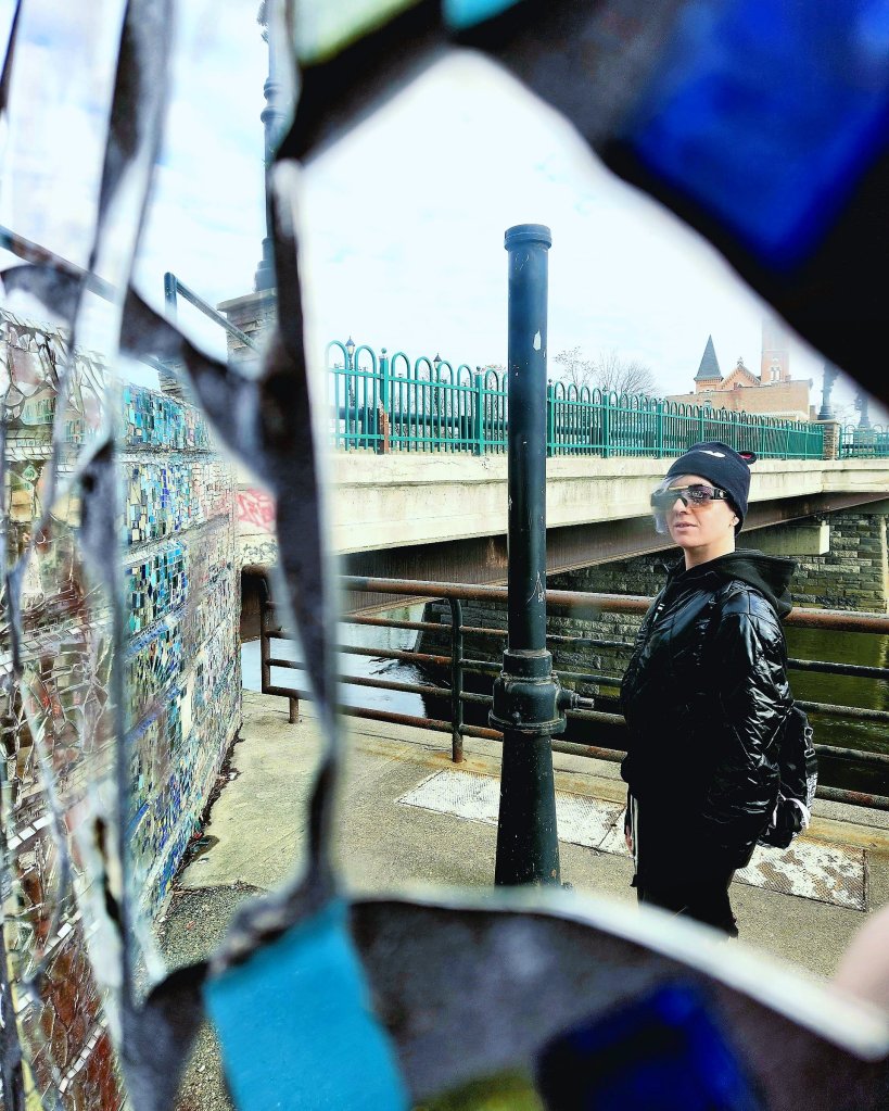 Kae Audhild Saturday stroll in December in Binghamton NY, mosaic art monument by the river downtown, New York attractions, alt lifestyle travel blogger, fashion style beauty influencer, tattooed pierced tall thin scandi American fitness model
