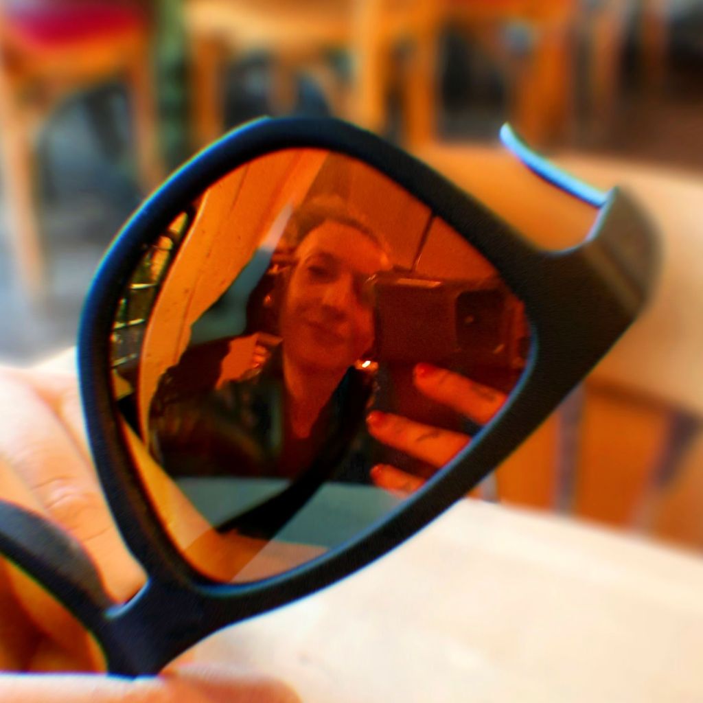 Kae Audhild selfie in orange mirror lens of goodr og black orange sunglasses at freedom of espresso in Syracuse new York, after playing nearby at central rock gym, adventures in cny, alt lifestyle fitness travel luxury beauty fashion tarot reader blogger vlogger influencer