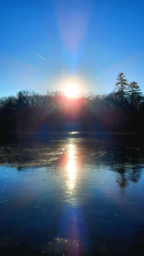 The sun's reflection on the icy surface of Lily Lake at Chenango Valley State Park in Chenango Forks, NY 