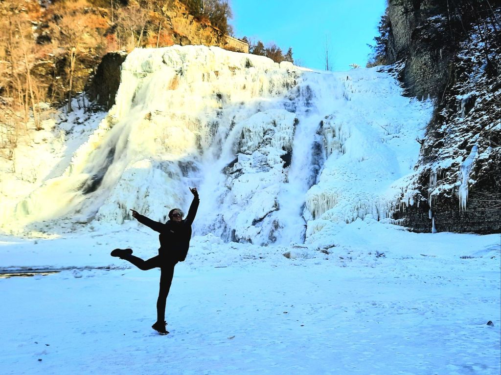 Kae Audhild dancing in front of an icy Ithaca Falls in late February 2025 - Ithaca, New York winters, waterfall photography