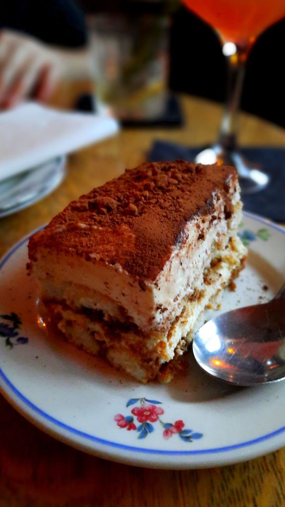 Tiramisu - house made tiramisu made with lady fingers soaked in Boozy Espresso, layered with Mascarpone Cream, and topped with a dusting of chocolate cookie crumble and espresso bean. 