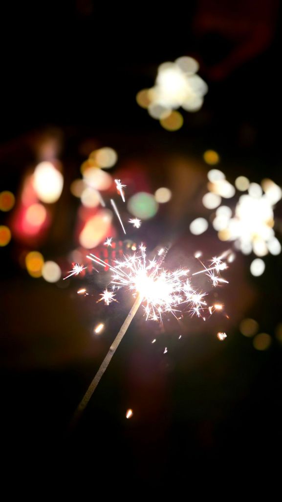 sparklers with friends around and campfire 
