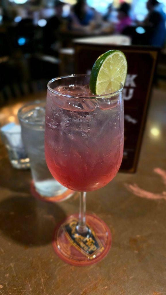 Cosmo Spritz - lemon vodka, elderflower liqueur, triple sec, cranberry juice, sour mix, and Starry.