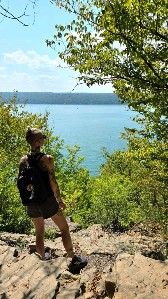 Kae Audhild standing on the edwards lake cliffs overlooking Cayuga Lake in Lansing, New York