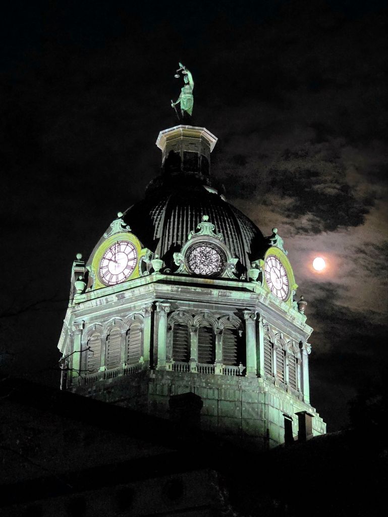Nearly full moon shining brightly behind the Broome County courthouse during the LUMA Projection Arts Festival 2025 in Binghamton, NY
