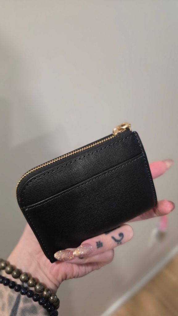 There is a small sleeve on the back side of the Kate Spade Devin zip card case.