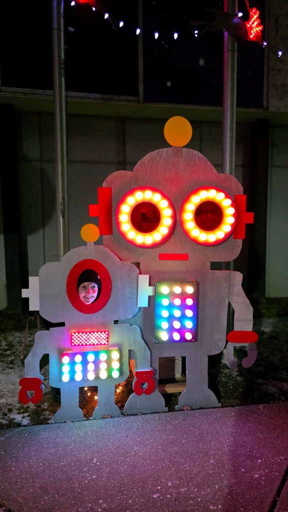 Home for the Holidays 2025 at Roberson Museum in Binghamton, NY - Kae Audhild poses with toy robot face cutout display in December 2025