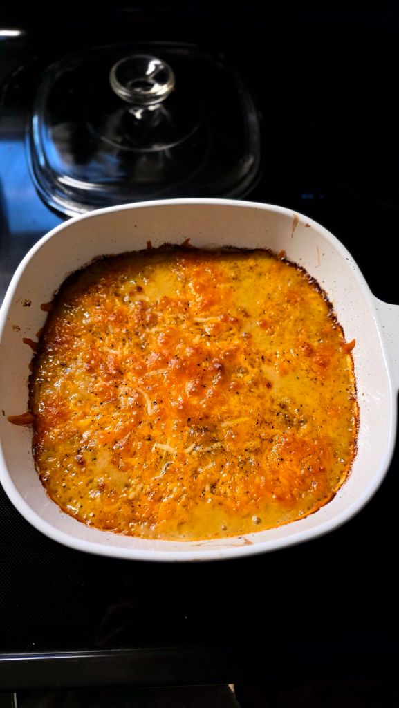 Cheeseburger casserole baked in a vintage square baking dish, filled with cheesy noodles and seasoned ground beef.