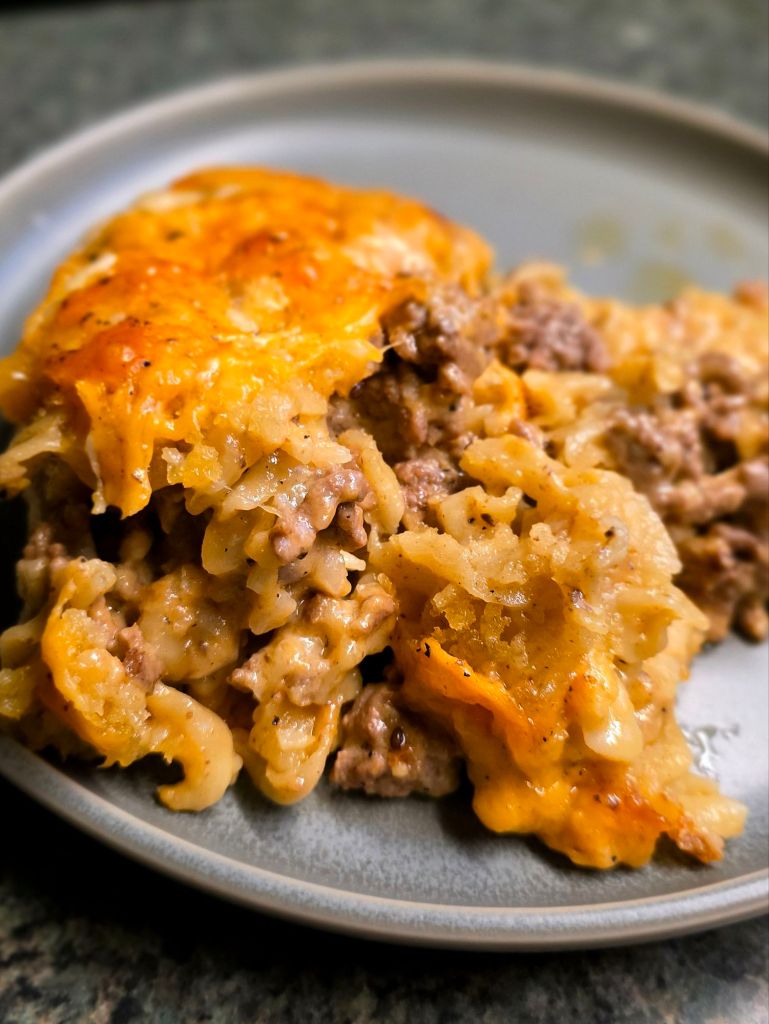 Serving of cozy cheeseburger casserole with ground beef and egg noodles, a simple and comforting baked dinner for cold nights.