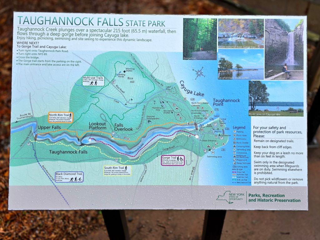 Taughannock Falls State Park trail map sign showing the gorge trail, North Rim Trail, and Cayuga Lake access points in Trumansburg, New York.