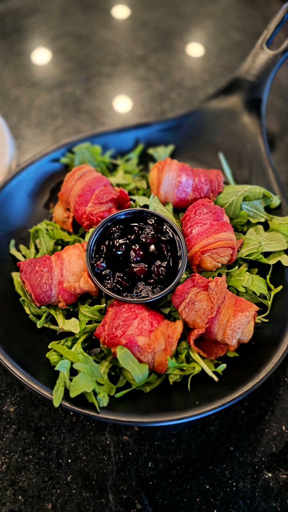 Bacon-wrapped scallops served over greens with blueberry jalapeño jam at The Preserve at 405, an upscale restaurant in Syracuse, NY.