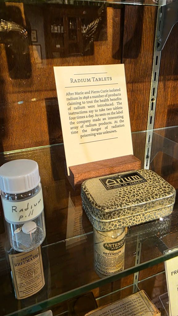 Display case showing historic radium medicine containers and tablets with informational signage at the Museum of Science & Technology in Syracuse, New York.